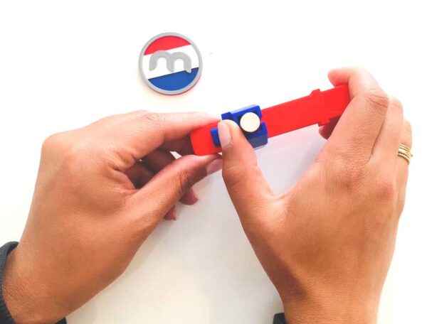 Red and blue plastic magnet dispenser with white circular button, dispenser maximum dimensions height 1.5mm Ø15mm
