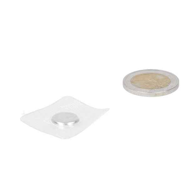 Silver round button battery next to a coin for sewing tray with PVC 12 x 2 mm with strong grip