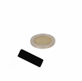 Neodymium block magnet 30x12x2 mm black epoxy coated next to a euro coin for scale comparison