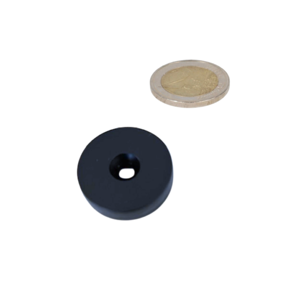 Black ring magnet with plastic protective layer and countersunk hole next to a coin to scale