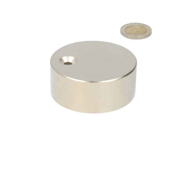 A neodymium magnet disc of 60 x 25 mm with countersunk hole and a polished metal finish for various applications