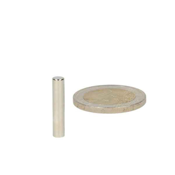 Silver-coloured high-grade neodymium magnet rod magnet 4 x 20 mm next to a euro coin by shell