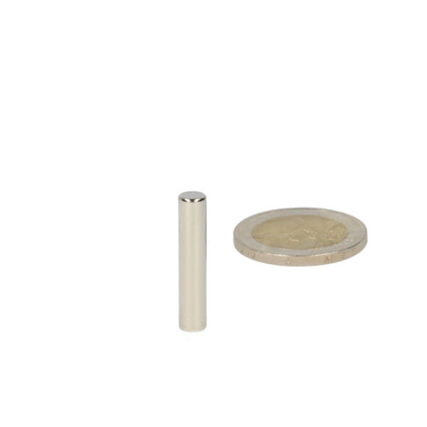 Silver cylindrical high-quality neodymium magnet 5 x 30 mm next to a coin for scale reference