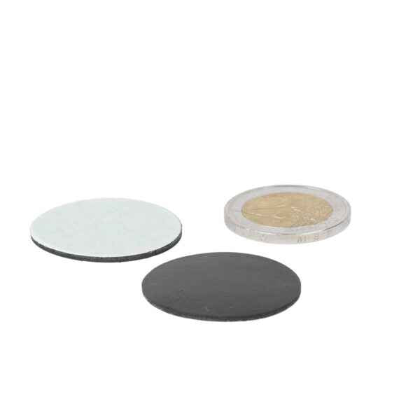 Black and silver magnetic disc next to a transparent coin with gold core self-adhesive rubber disc 40mm